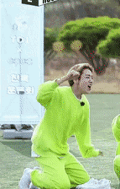 a man in a neon green outfit is kneeling on the ground
