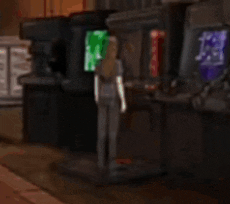 a blurry picture of a woman standing in front of a row of arcade machines