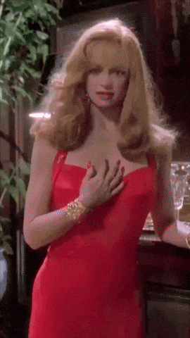 a woman in a red dress is touching her chest with her hand