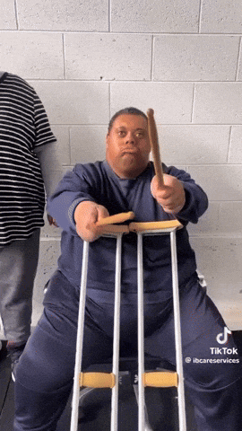 a man with crutches is holding a stick in his right hand