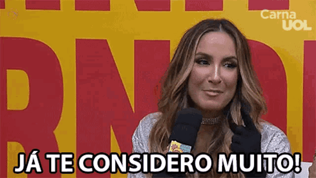 a woman talking into a microphone with the words " ja te considero muito " on the bottom