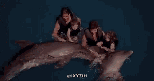 a group of people are swimming in the ocean with a shark .