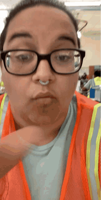 a woman wearing glasses and an orange vest