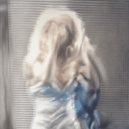 a blurry picture of a person 's face with a blue shirt on