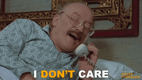 a man laying in bed talking on a phone with the words i do n't care in orange