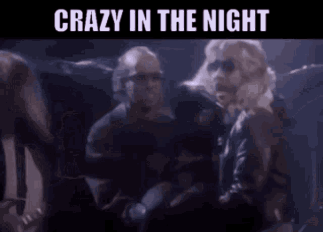 a group of people standing in a dark room with the words `` crazy in the night '' written above them .