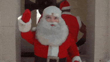 a man dressed as santa claus waving his hand