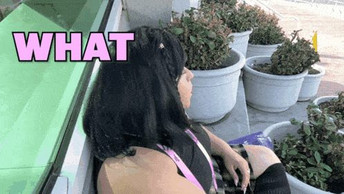 a woman sitting in front of a window with the word what above her head