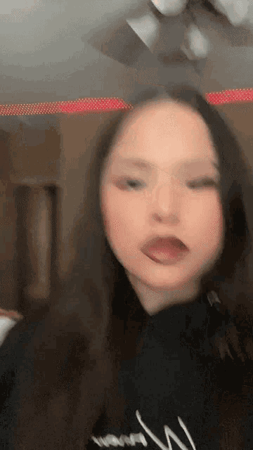 a woman is making a funny face with her tongue out .