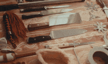 a bunch of knives on a table including one that says ' ninja ' on it