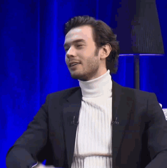 a man wearing a turtleneck and a black jacket