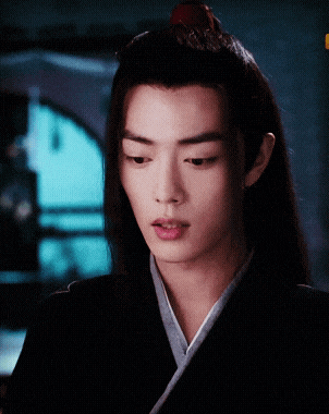 a close up of a man 's face with a red flower in his hair