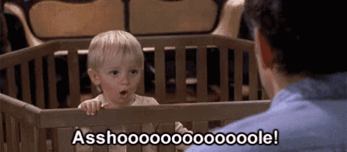 a man is looking at a baby in a crib and says `` asshoooo '' .