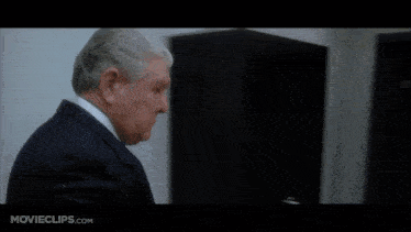 a movie clip from movieclips.com shows a man in a suit talking to another man in a white shirt