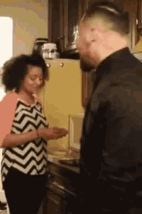 a man and a woman are standing in a kitchen