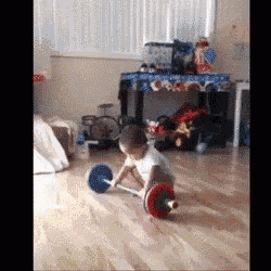 a baby is playing with a barbell on the floor in a living room .