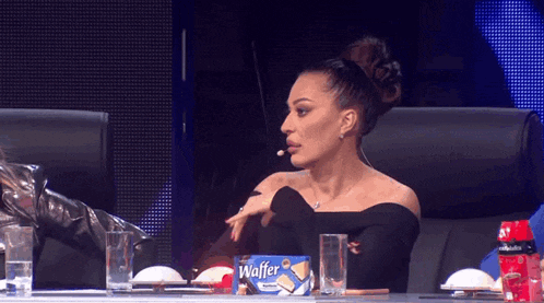 a woman sits at a table with a box of waffer on it