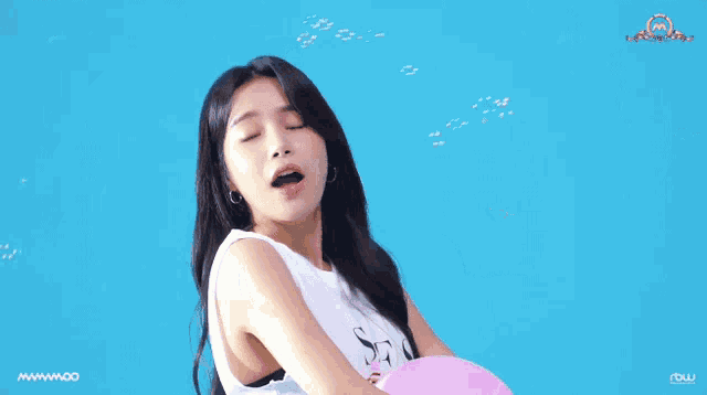 a woman is blowing soap bubbles while holding a pink balloon