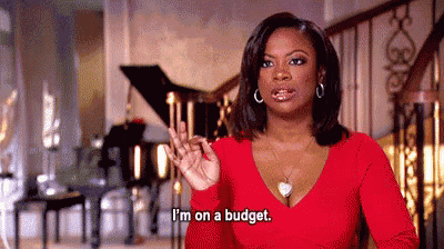 a woman in a red dress is standing in front of a piano and says `` i 'm on a budget '' .