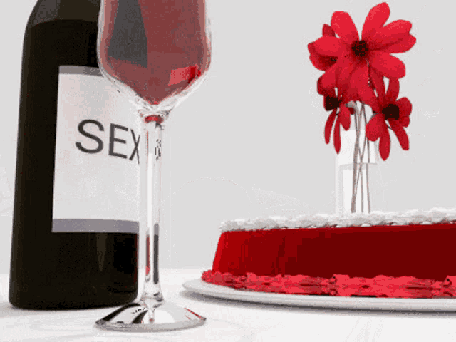 a bottle of sex wine next to a glass of wine and a cake