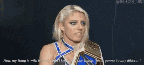a female wrestler is holding a wrestling belt and talking to someone .