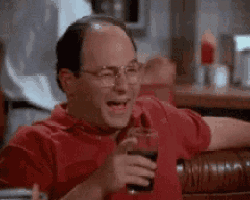 a man in a red shirt is holding a glass of soda .