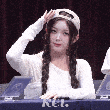 a girl sitting at a table with kei written on the table