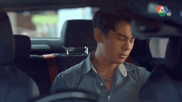 a man is sitting in the back seat of a car with the number 7 in the rear view mirror