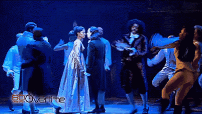 a group of people are dancing on a stage and the word overtime is on the bottom left