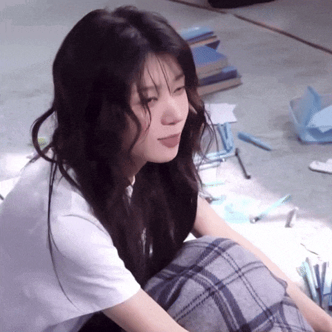 a woman is sitting on the floor with her legs crossed and her tongue out