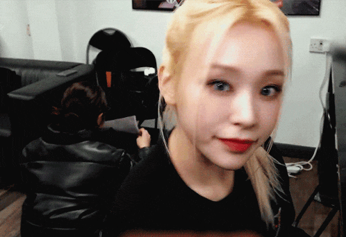 a woman with blonde hair is wearing a black shirt