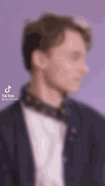 a blurry picture of a man wearing a tie and a jacket .