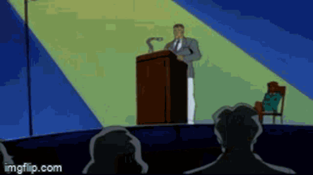 a man is giving a speech at a podium in front of a crowd of people .