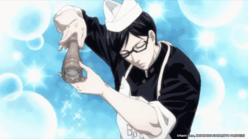 a man in a chef 's hat and apron holds a pepper mill