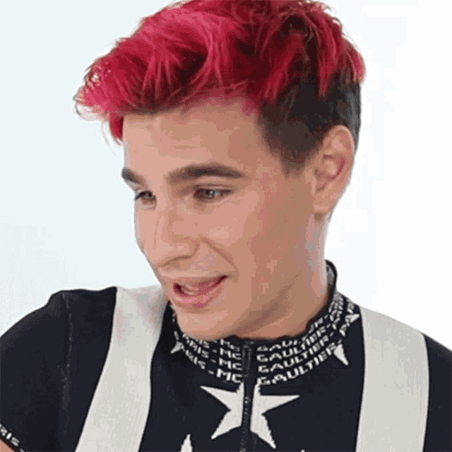 a man with red hair is wearing a black and white sweater with a white star on it