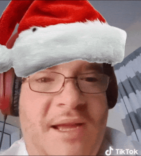 a man wearing glasses and a santa hat has a tiktok logo on his face