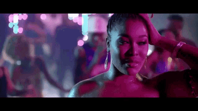 a woman is standing in front of a crowd of people at a party in a club .
