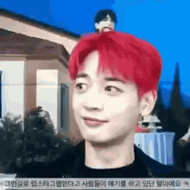 a man with red hair is looking at the camera .