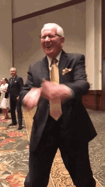 an older man in a suit and tie is dancing