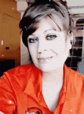 a woman wearing an orange shirt that says devils