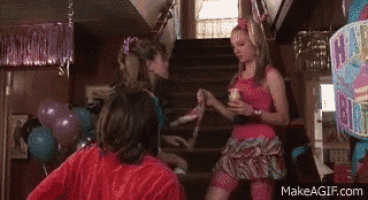 a woman in a pink dress is standing on a set of stairs talking to another woman .