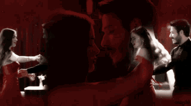 a man and a woman are dancing in a dark room with a red background
