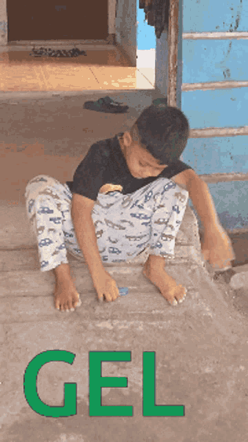 a young boy is sitting on the ground with the word gel in the corner