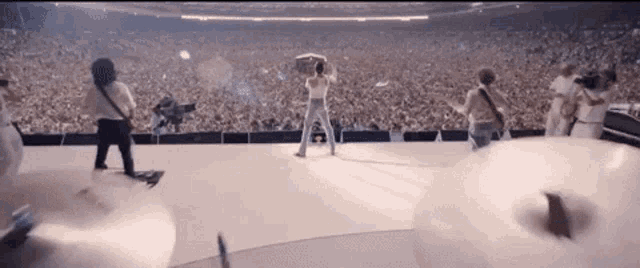 a group of people standing on top of a stage in front of a crowd .