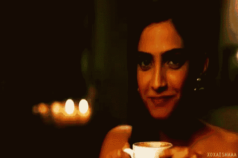 a woman is smiling while holding a glass of wine ..