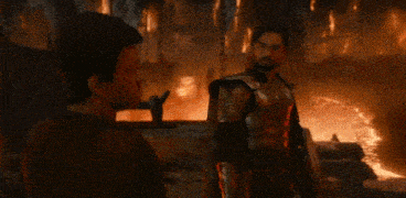 two men in armor are standing next to each other in a cave .