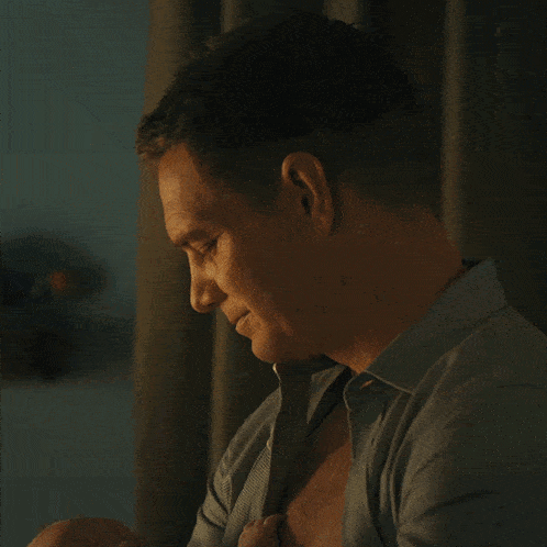 a man is holding a baby in his arms and the baby is wearing a pacifier