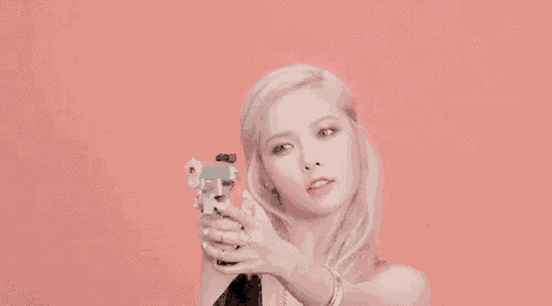 a woman is holding a toy gun in her hand .