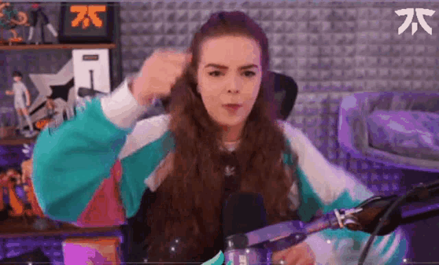 a woman with long hair is standing in front of a microphone with a sign that says 75 in the background