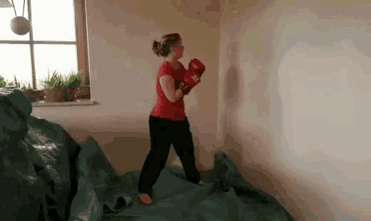 a woman wearing red boxing gloves with the number 12 on them